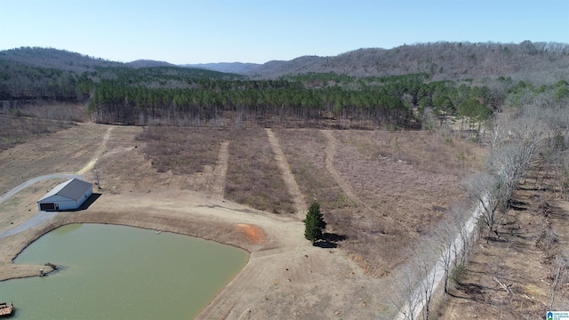 drone / aerial view with a forest view and a water and mountain view