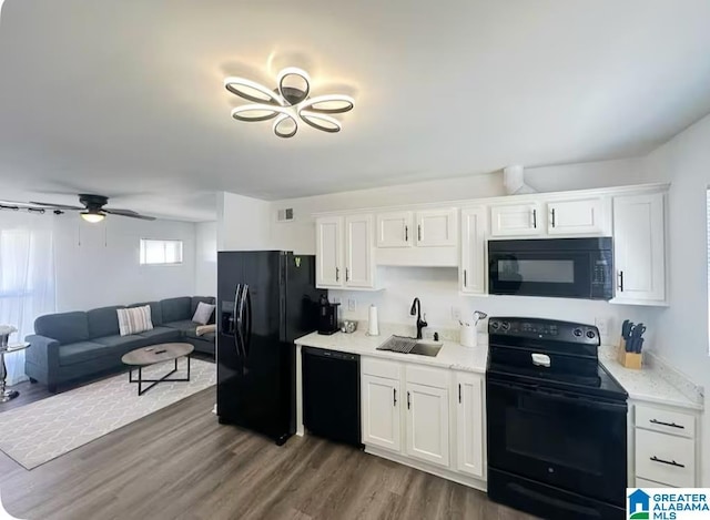 kitchen featuring ceiling fan, dark wood-style flooring, a sink, white cabinets, and black appliances