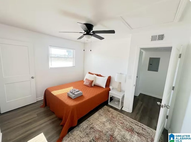 bedroom with ceiling fan, electric panel, visible vents, and wood finished floors