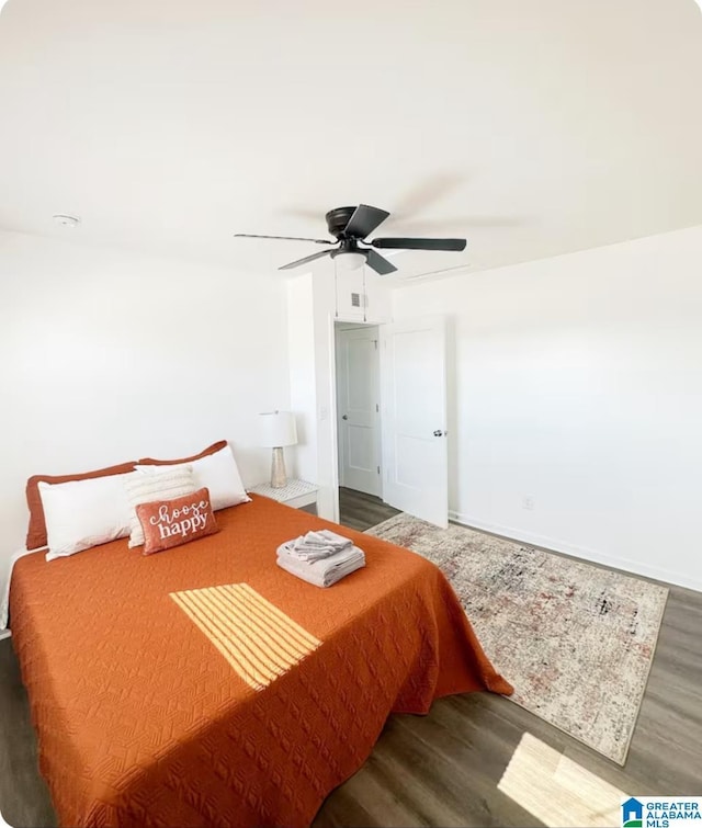 bedroom featuring visible vents, ceiling fan, baseboards, and wood finished floors