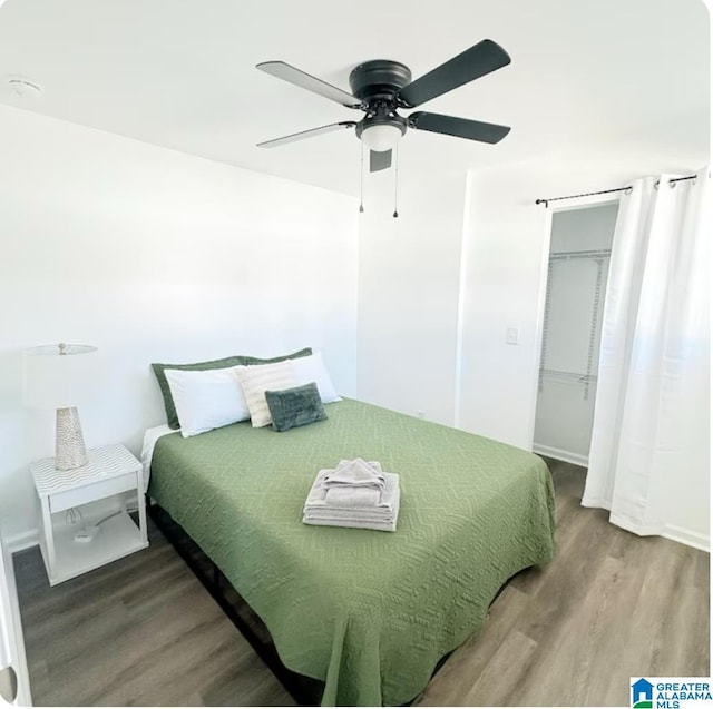 bedroom featuring a closet, wood finished floors, and a ceiling fan