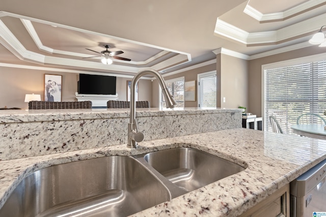 interior space with dishwasher, a ceiling fan, a tray ceiling, crown molding, and a sink