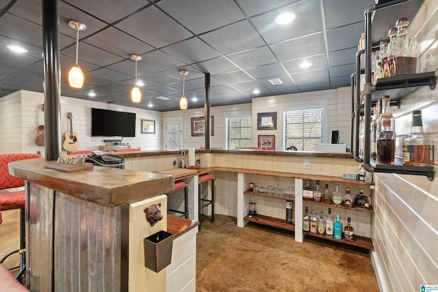 kitchen with carpet floors, open floor plan, a drop ceiling, and decorative light fixtures