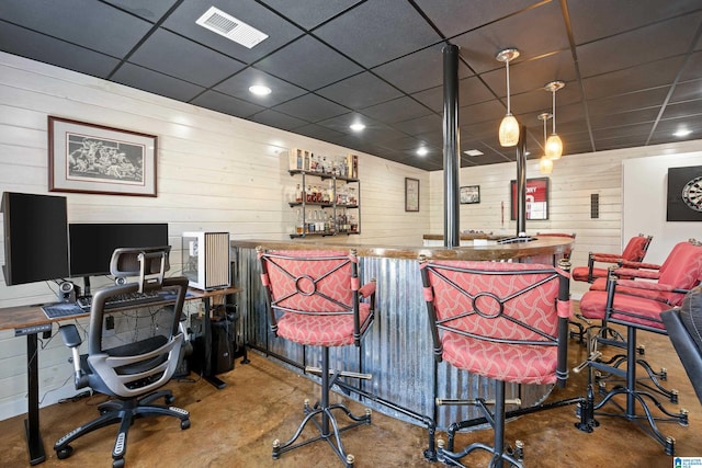 bar featuring a dry bar, wooden walls, visible vents, a drop ceiling, and concrete flooring