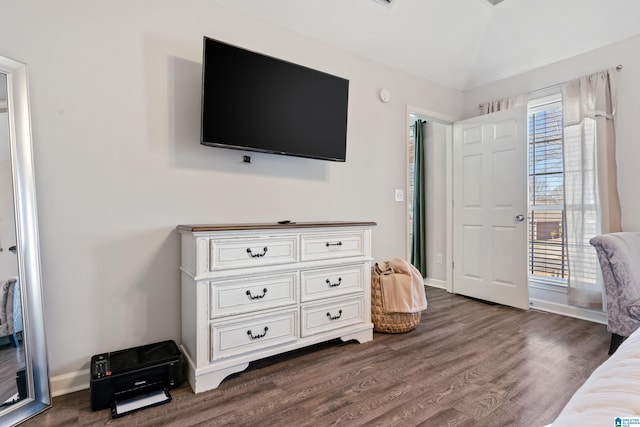 bedroom with dark wood-type flooring, lofted ceiling, and baseboards