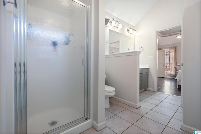 ensuite bathroom featuring lofted ceiling, a shower stall, vanity, and tile patterned floors