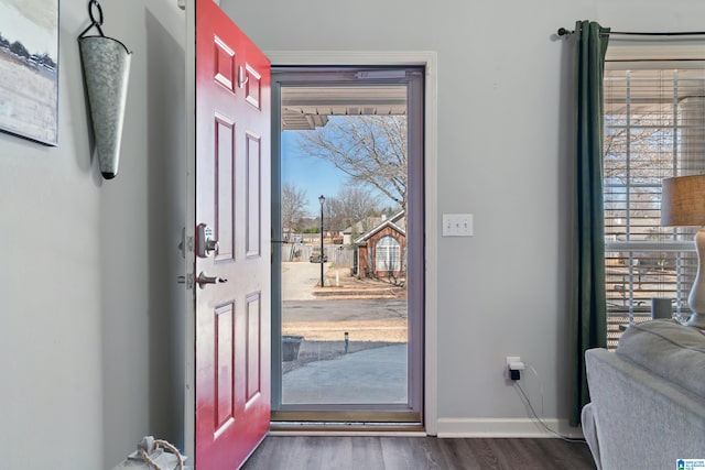 foyer entrance with dark wood-style floors and baseboards