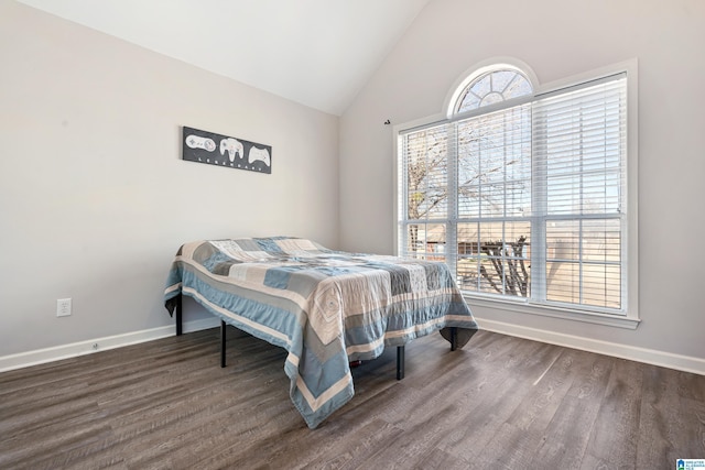 bedroom with lofted ceiling, baseboards, and wood finished floors