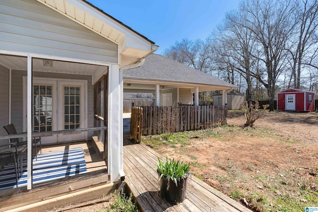 view of yard with an outdoor structure, a wooden deck, a storage shed, and fence