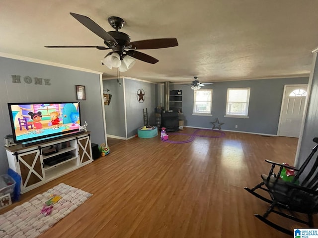 living area with crown molding, baseboards, and wood finished floors