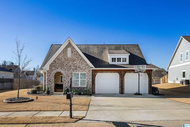 view of front of property with brick siding, central air condition unit, concrete driveway, an attached garage, and fence