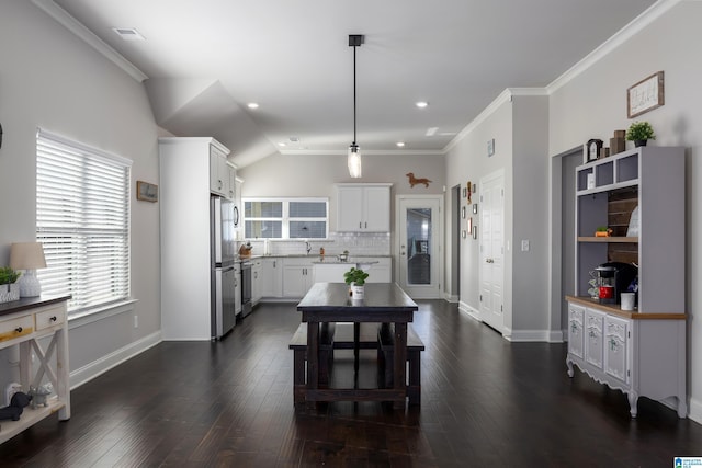 kitchen with dark wood-style flooring, white cabinetry, light countertops, freestanding refrigerator, and decorative backsplash