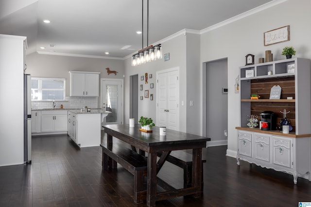 kitchen featuring tasteful backsplash, dark wood-style flooring, white cabinets, and crown molding