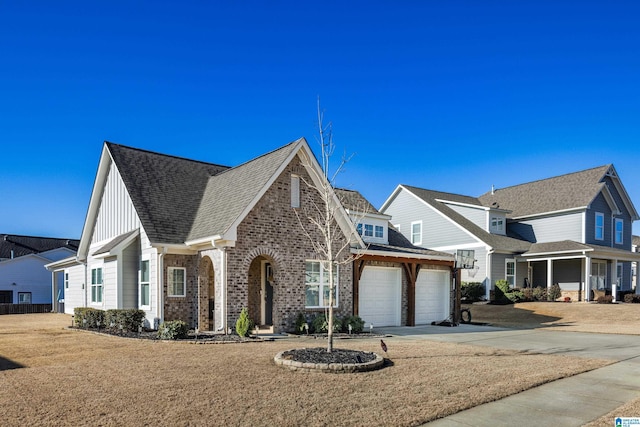 view of front of home featuring a garage, brick siding, driveway, roof with shingles, and board and batten siding