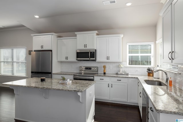 kitchen with visible vents, appliances with stainless steel finishes, a sink, and white cabinetry