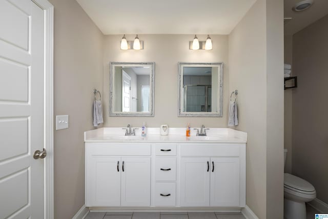 full bath with toilet, baseboards, and a sink