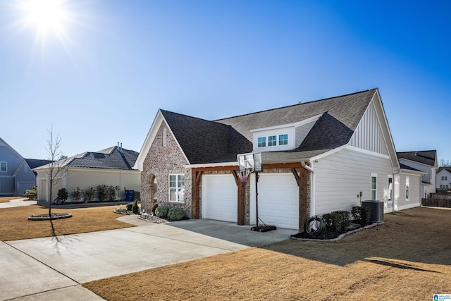 view of front of home featuring a garage, cooling unit, concrete driveway, and brick siding