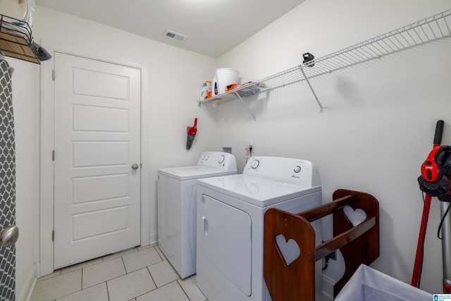 clothes washing area with laundry area, visible vents, independent washer and dryer, and light tile patterned floors