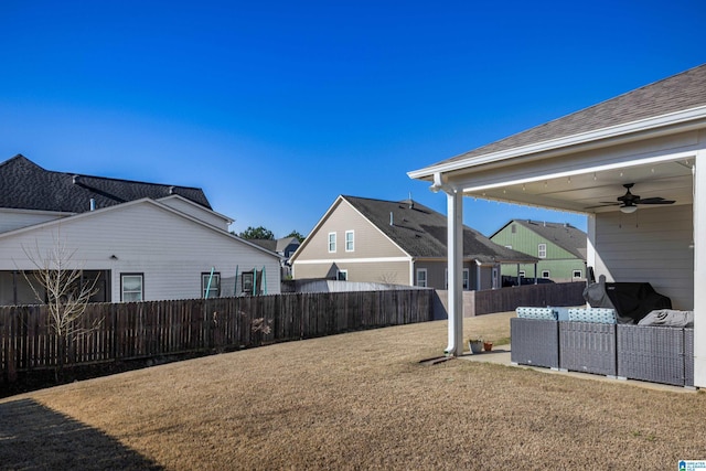 view of yard with outdoor lounge area, a fenced backyard, and a ceiling fan