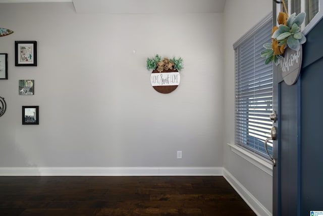 unfurnished room featuring dark wood-style floors and baseboards