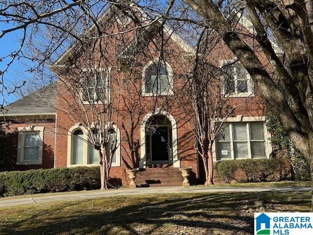 view of front of property with a front lawn and brick siding