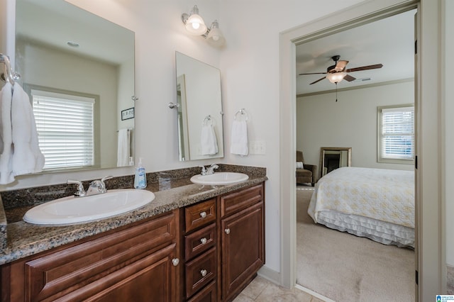 full bath with double vanity, ensuite bath, ceiling fan, and a sink