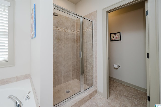 bathroom with a garden tub, tile patterned flooring, a shower stall, and baseboards