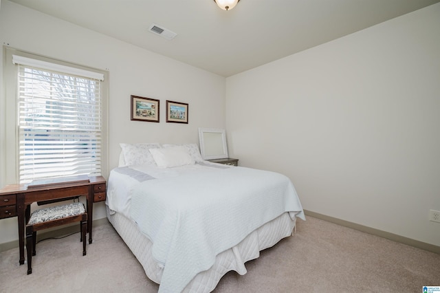 bedroom with light carpet, visible vents, and baseboards