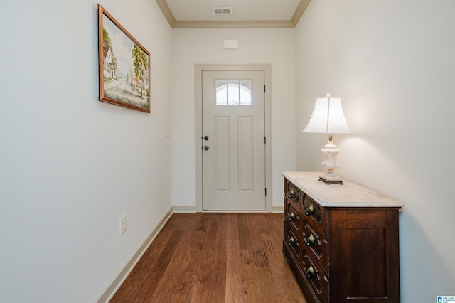 foyer entrance with baseboards, visible vents, dark wood finished floors, and crown molding