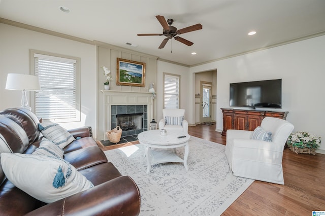 living area featuring plenty of natural light, crown molding, and wood finished floors