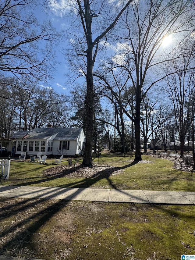 view of front of house with a chimney and a front lawn