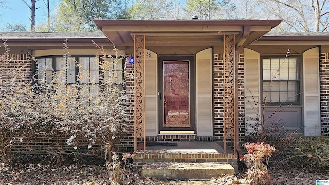 view of exterior entry with brick siding