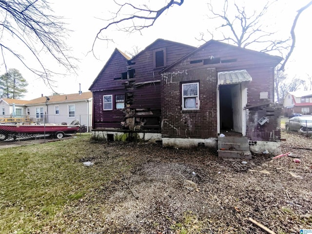 view of front of property featuring brick siding, a front yard, and fence