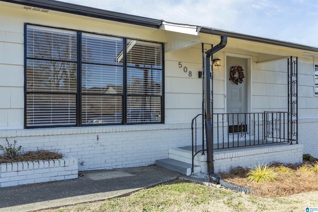 doorway to property with brick siding