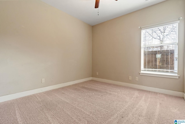 carpeted spare room with baseboards and a ceiling fan