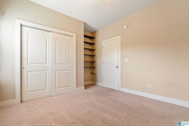 unfurnished bedroom with a closet, carpet flooring, and baseboards