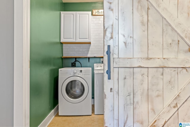 laundry room featuring cabinet space, electric dryer hookup, and light tile patterned floors