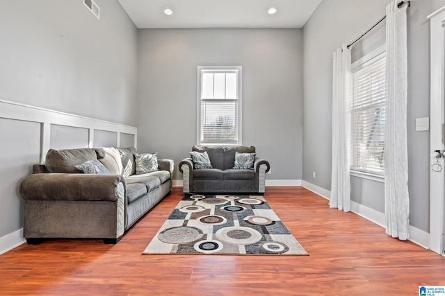 living area featuring a wealth of natural light, wood finished floors, and visible vents