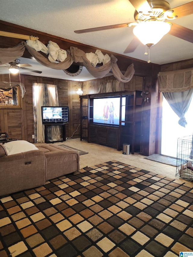 living room featuring light carpet, wood walls, a textured ceiling, and a ceiling fan