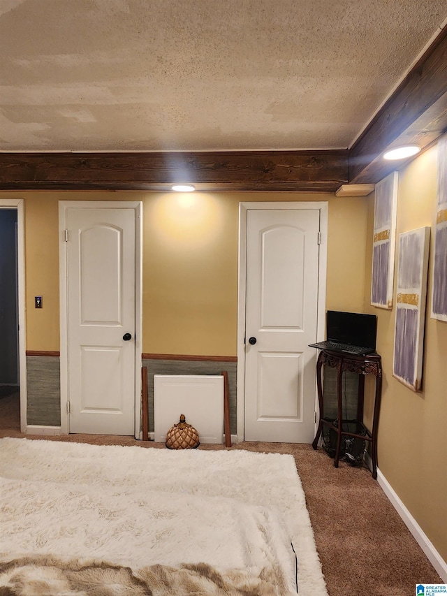 carpeted bedroom with baseboards and a textured ceiling