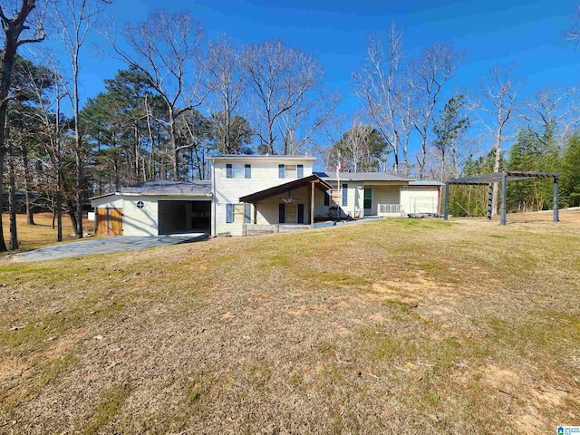 back of house with a yard, driveway, and a pergola