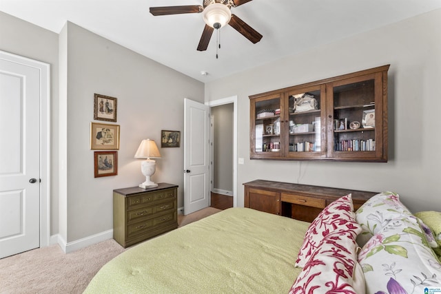 carpeted bedroom with a ceiling fan and baseboards