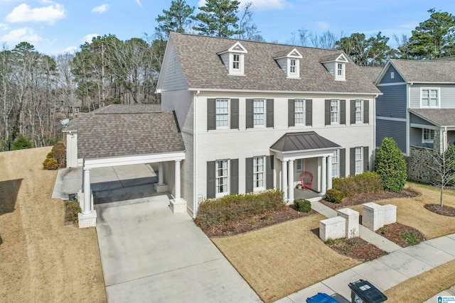 view of front of house with driveway, roof with shingles, a garage, and a front yard