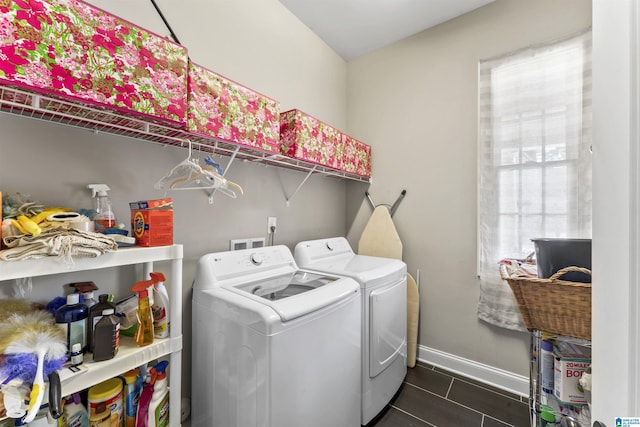 clothes washing area featuring laundry area, washer and clothes dryer, and baseboards