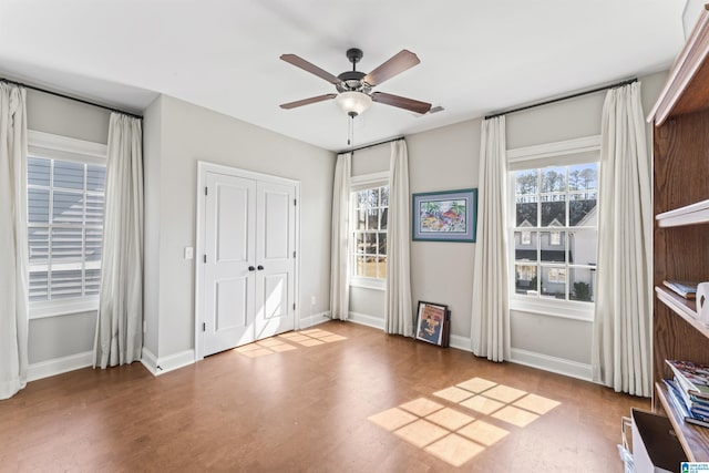 unfurnished bedroom with a ceiling fan and baseboards