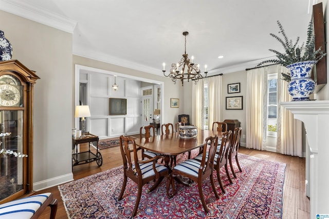 dining room featuring an inviting chandelier, baseboards, ornamental molding, and wood finished floors