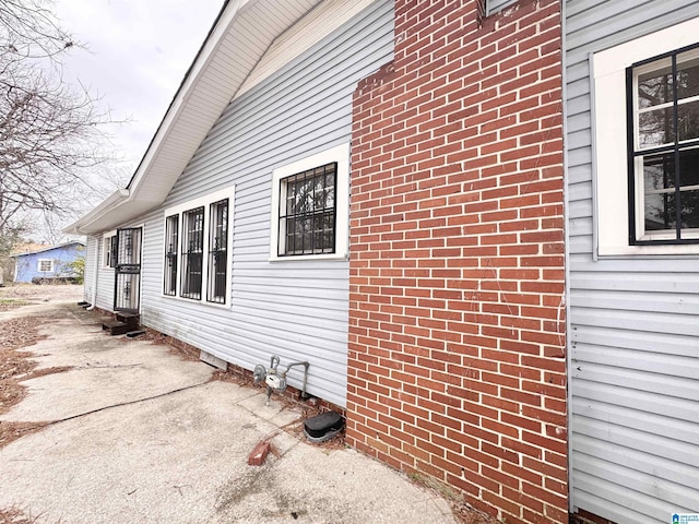 view of side of property with a patio and brick siding