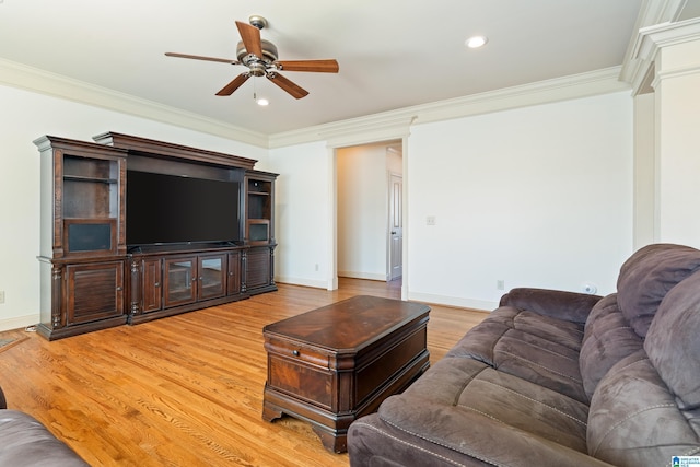 living room featuring a ceiling fan, light wood-style flooring, ornamental molding, and baseboards