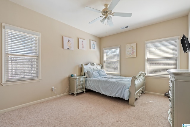 bedroom featuring light colored carpet, ceiling fan, visible vents, and baseboards