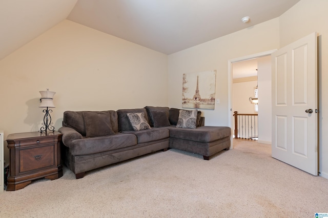 carpeted living area with vaulted ceiling